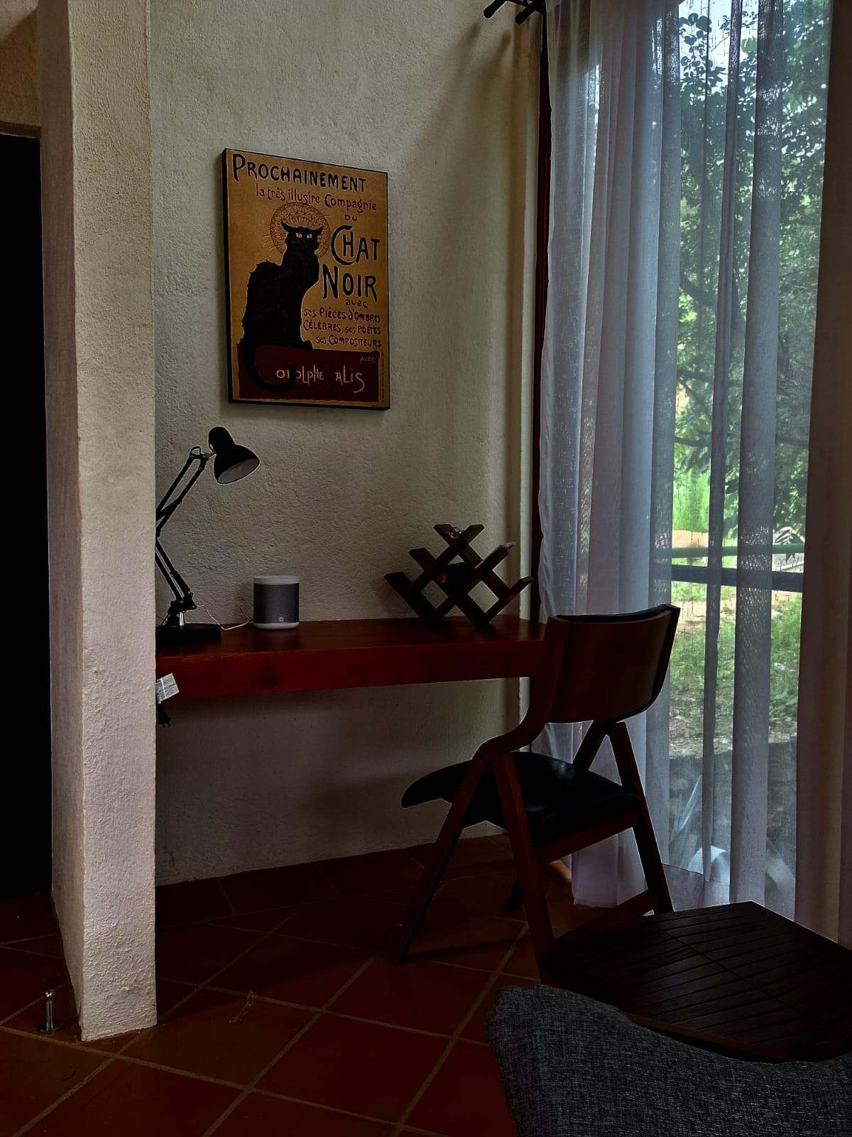 Escritorio en la Cabaña Las Águilas junto a ventanal, con lámpara y decoración de pared.