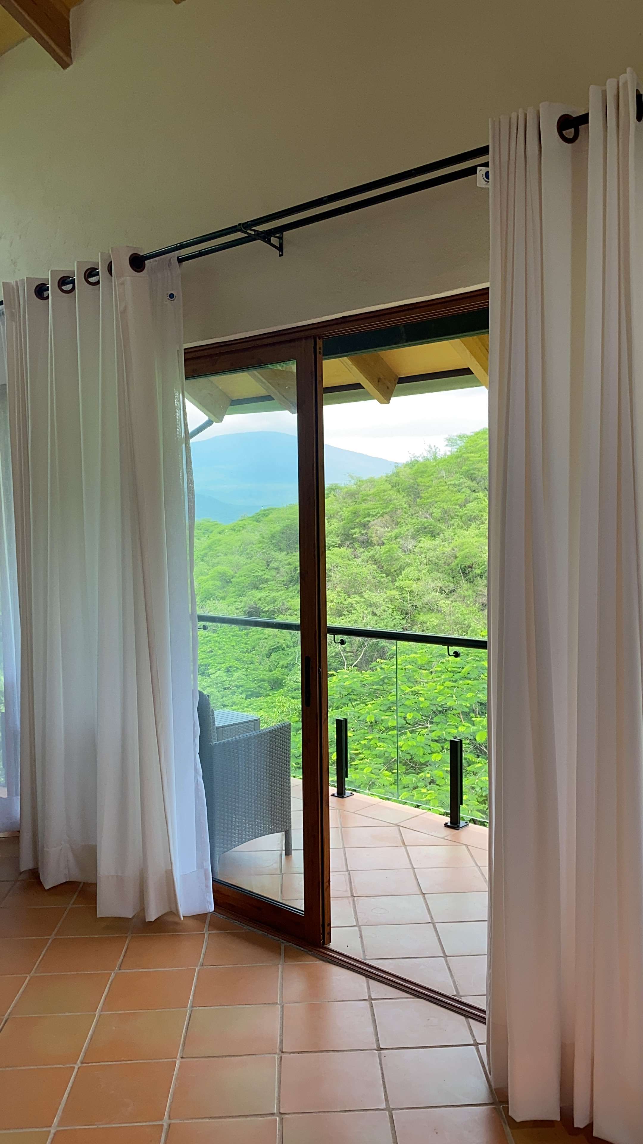 Vista desde el interior de la Cabaña Las Águilas hacia la terraza y la naturaleza.