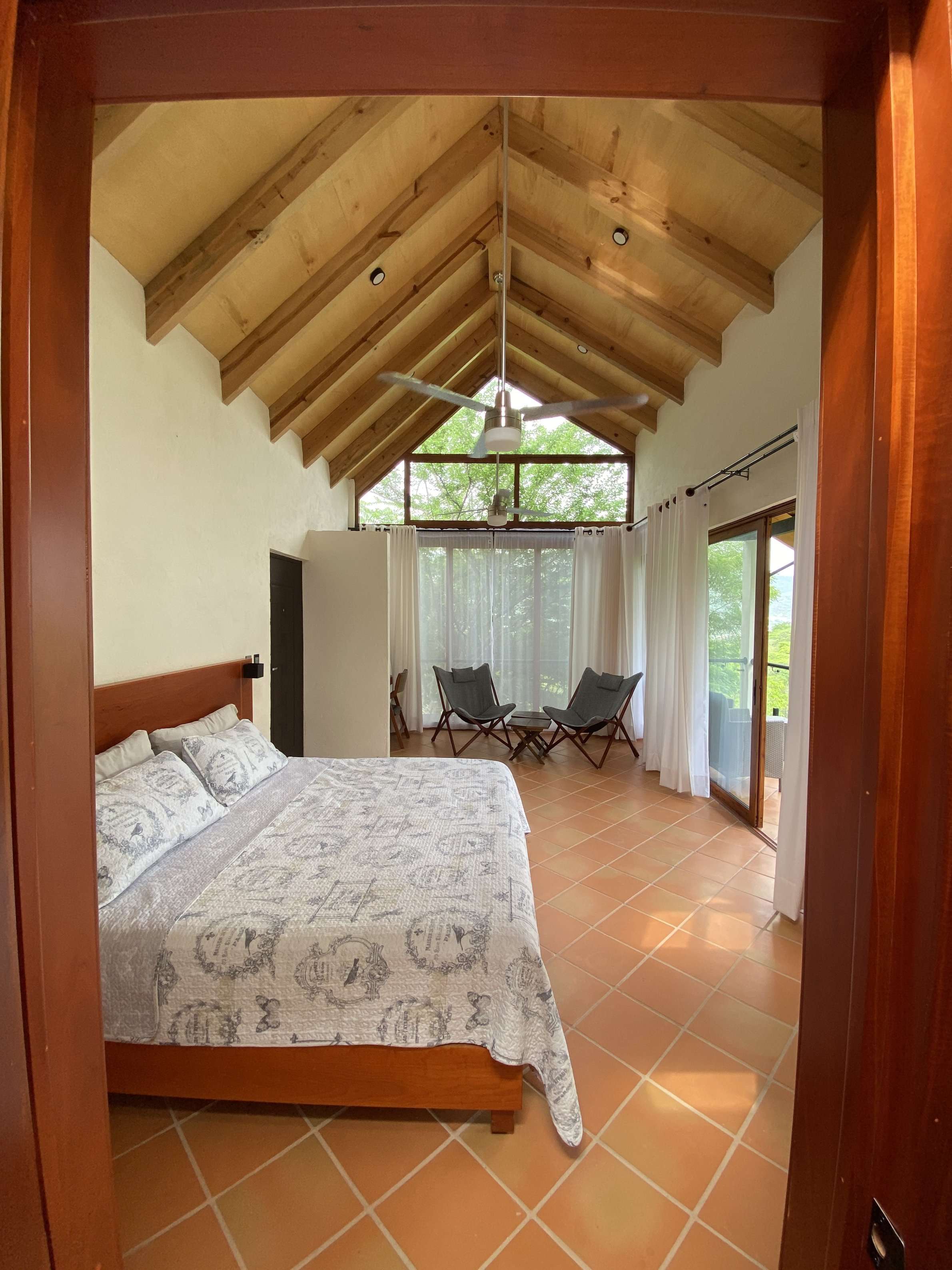 Vista desde la entrada de la Cabaña Las Águilas mostrando la cama y sala junto al ventanal.