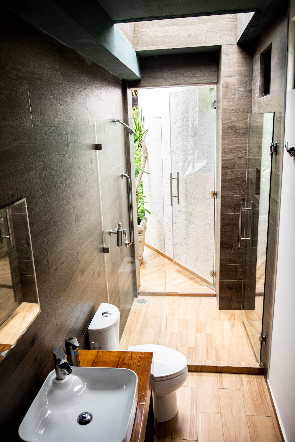 Vista desde la cama de la Habitación El Palomar hacia la terraza con mesa servida y vegetación al fondo.